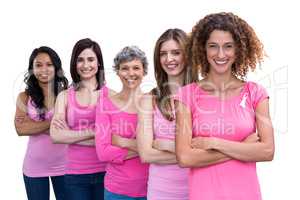 Smiling women in pink outfits standing in a line for breast canc