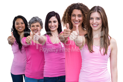 Smiling women in pink outfits showing thumbs up for breast cance