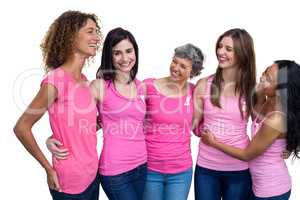 Smiling women in pink outfits posing for breast cancer awareness