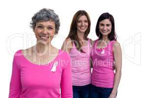 Smiling women in pink outfits posing for breast cancer awareness