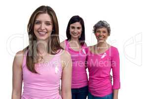 Smiling women in pink outfits posing for breast cancer awareness