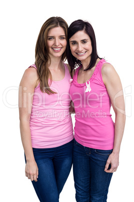 Smiling women in pink outfits posing for breast cancer awareness