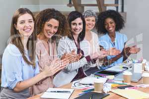 Group of interior designers applauding in office