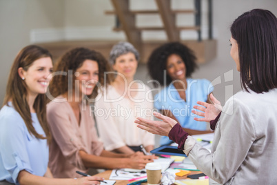 Woman giving presentation to her colleagues