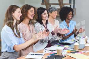 Group of interior designers applauding in office