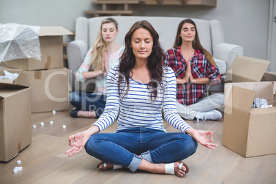 Friends performing yoga in their new house