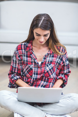 Beautiful woman using a laptop in living room