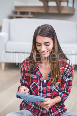 Beautiful woman using digital tablet in living room