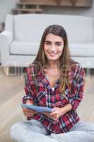 Beautiful woman using digital tablet in living room