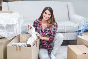 Beautiful woman unpacking carton boxes