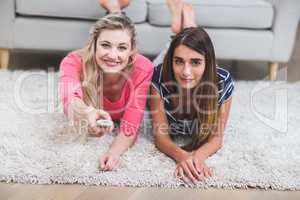 Two beautiful women watching television in living room