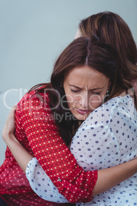 Depressed woman embracing her friend