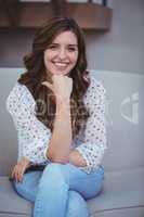 Portrait of beautiful woman sitting on sofa