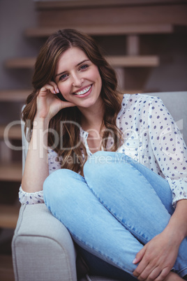 Portrait of beautiful woman sitting on sofa