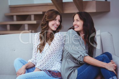 Two beautiful sitting back to back on sofa