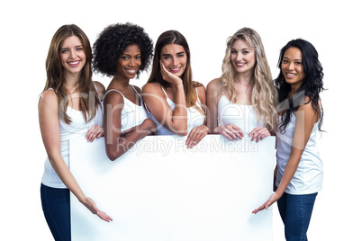 Multiethnic women holding white board