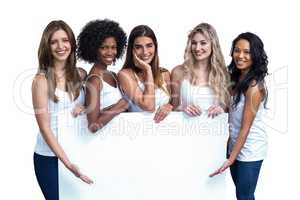 Multiethnic women holding white board