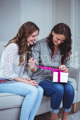 Friends unwrapping a gift in living room