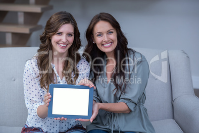 Two beautiful woman holding digital tablet