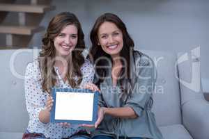 Two beautiful woman holding digital tablet