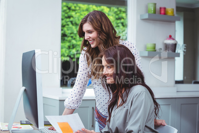 Two beautiful woman using computer