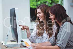 Two beautiful woman using computer