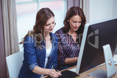 Two beautiful woman using computer and pen tablet