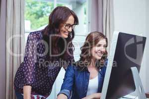 Two beautiful woman using computer