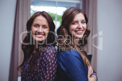 Portrait of beautiful women standing back to back