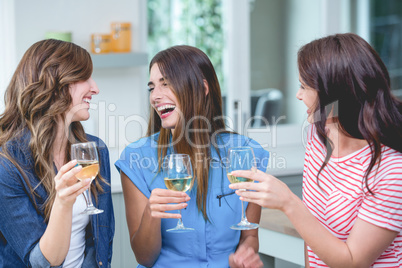 Friends holding glass of wine at home