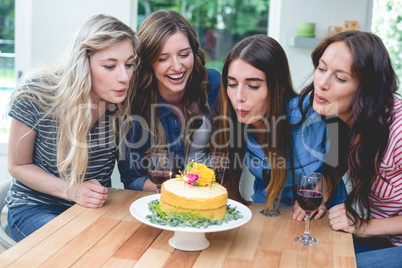 Friends blowing the candles on a birthday cake