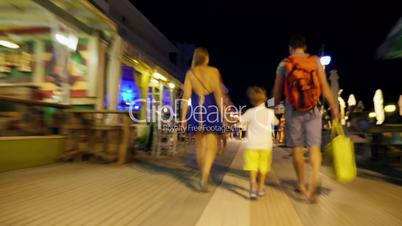 Hyperlapse of family walking along street at night