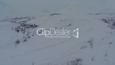 Car on heavy snowy road in mountains, aerial view