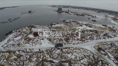 Aerial view of car driving to waterside in winter