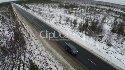 Aerial view of minivan driving winter road