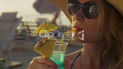 Woman in Hat and Sunglasses Drinking Cocktail
