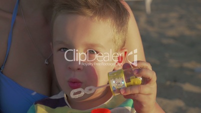 Little happy child blowing bubbles outdoor