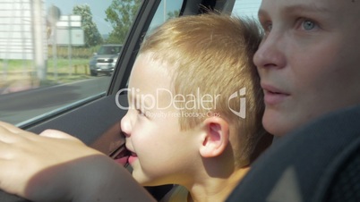 Mother and son looking out car window