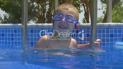 Smiling Boy in Goggles in Swimming Pool