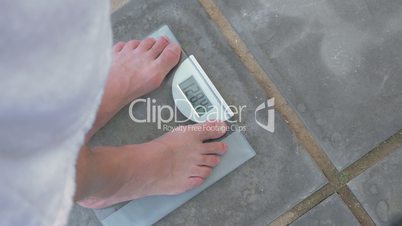Man weighing himself on bathroom scales
