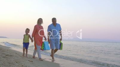 Family walk on the beach after shopping