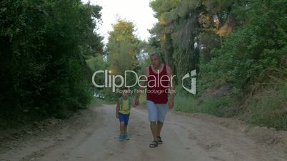 Man and Boy Hiking along the Country Road