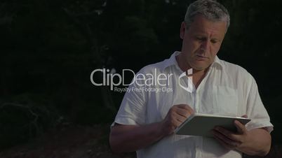 Man Typing in Tablet in Twilight