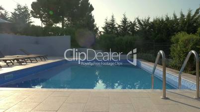 Outdoor swimming pool and empty deck-chairs