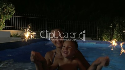 Woman and Boy with Sparklers in Pool