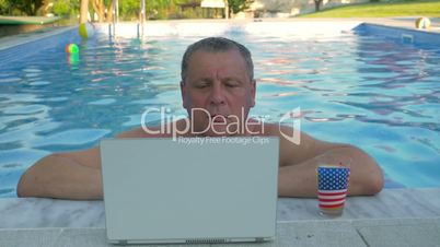 Smiling Man in Home Pool with Laptop