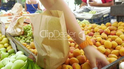 Buyer Putting Apricots into Paper Bag