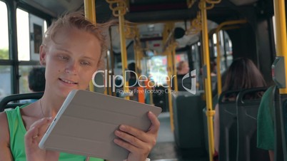 Smiling Woman with Tablet in Bus