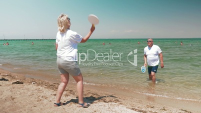 Man and woman playing badminton on beach