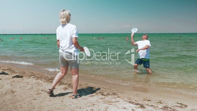 Mature Couple Playing Racket Ball on the Beach